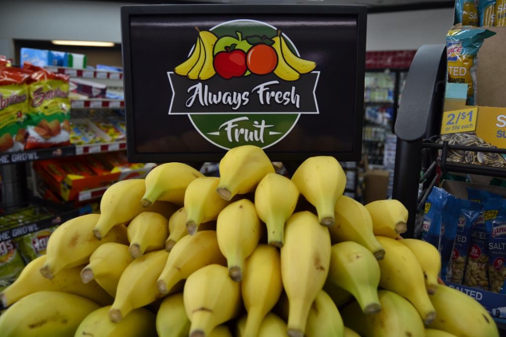 Bananas piled high under Always Fresh Fruit branded sign