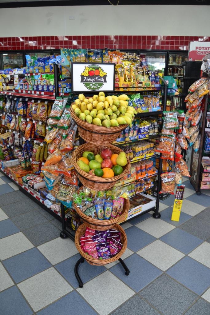 4-tier wicker basket display stand with fruit and snacks in convenience store