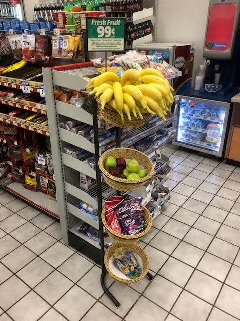 Store shelf produce display with bananas and apples