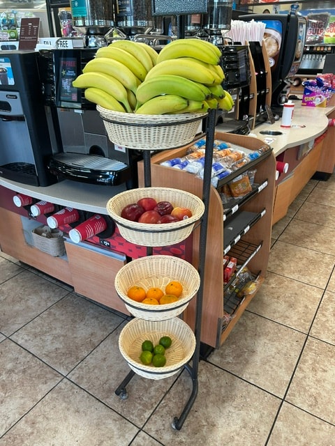 White basket display with bananas, apples, oranges and limes